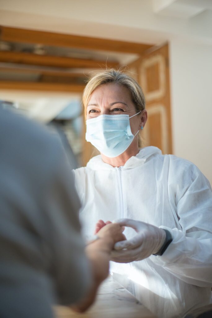 Woman Wearing Face Mask and Gloves. An image of a doctor having a discussion with a patient promotes the advice to make informed vaccine decisions.